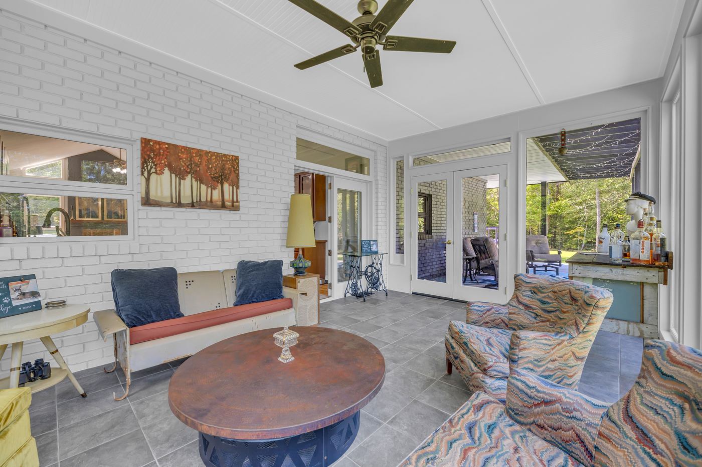 The sunroom, with the door out to the porch and the open glass door to the kitchen at left